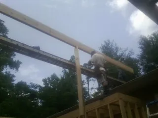 Carpenter setting a ridge beam over a new addition frame — Ice Dam Removal by Roofing Brothers in Point Reyes Station