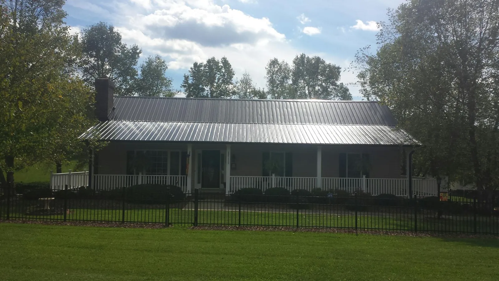Gray metal roof on a brick ranch with a full width front porch — Gutter Guard Installation work by our crew in Point Reyes Station